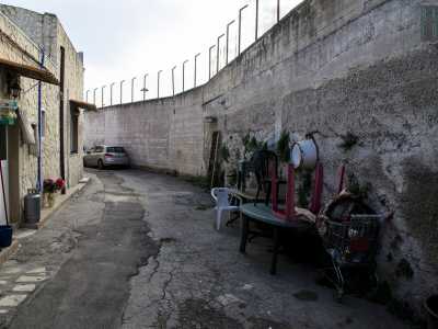 Via Giuseppe Colapietro, strada circondata da un alto muro di cemento  